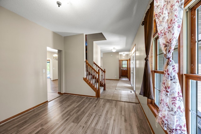 25100 Lincoln Dr NE, Athens Twp, MN 55040 - hall featuring plenty of natural light, light wood finished floors, a chandelier, and baseboards