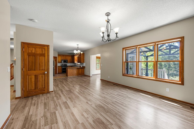 25100 Lincoln Dr NE, Athens Twp, MN 55040 - unfurnished living room with a chandelier, light wood-type flooring, baseboards, and a textured ceiling