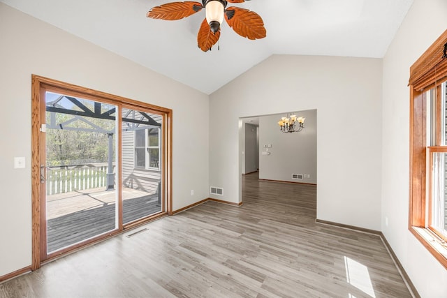 25100 Lincoln Dr NE, Athens Twp, MN 55040 - spare room featuring a chandelier, vaulted ceiling, light wood-type flooring, plenty of natural light, and ceiling fan