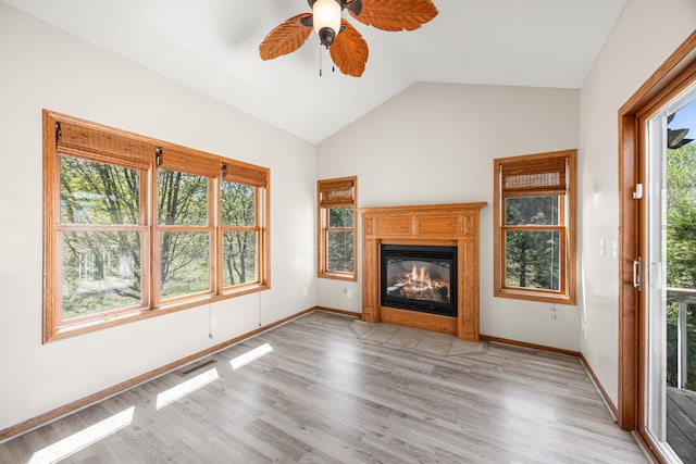 25100 Lincoln Dr NE, Athens Twp, MN 55040 - unfurnished living room featuring lofted ceiling, light wood-type flooring, ceiling fan, a glass covered fireplace, and baseboards