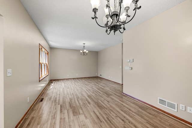 25100 Lincoln Dr NE, Athens Twp, MN 55040 - unfurnished dining area with a chandelier, light wood-style flooring, and baseboards