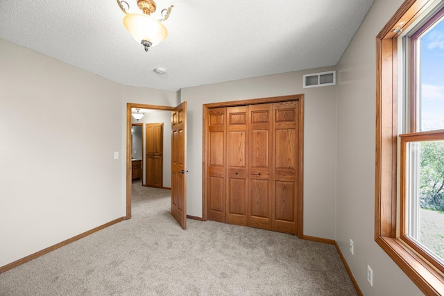 25100 Lincoln Dr NE, Athens Twp, MN 55040 - unfurnished bedroom featuring light colored carpet, multiple windows, baseboards, and a textured ceiling