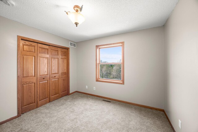 25100 Lincoln Dr NE, Athens Twp, MN 55040 - unfurnished bedroom featuring carpet flooring, a closet, baseboards, and a textured ceiling