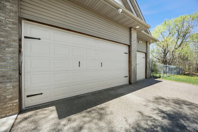 25100 Lincoln Dr NE, Athens Twp, MN 55040 - garage featuring asphalt driveway and fence