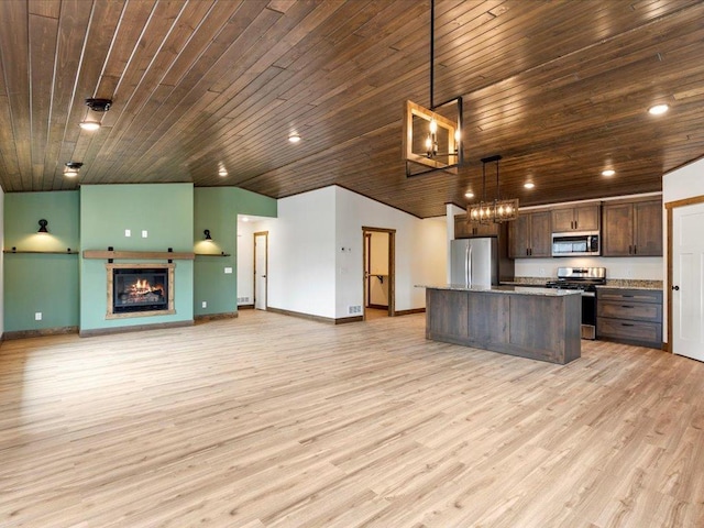 kitchen featuring appliances with stainless steel finishes, a chandelier, baseboards, dark brown cabinets, and open floor plan