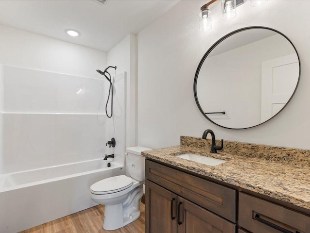bathroom with wood finished floors, toilet, vanity, and  shower combination