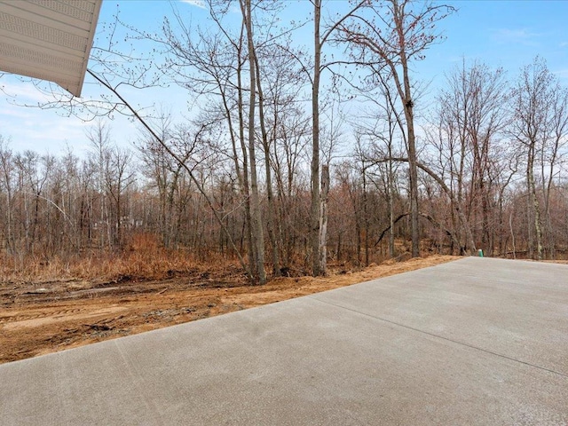 view of concrete road featuring a forest view