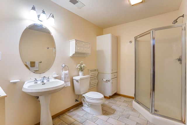 full bath featuring a stall shower, toilet, baseboards, tile patterned floors, and a textured ceiling