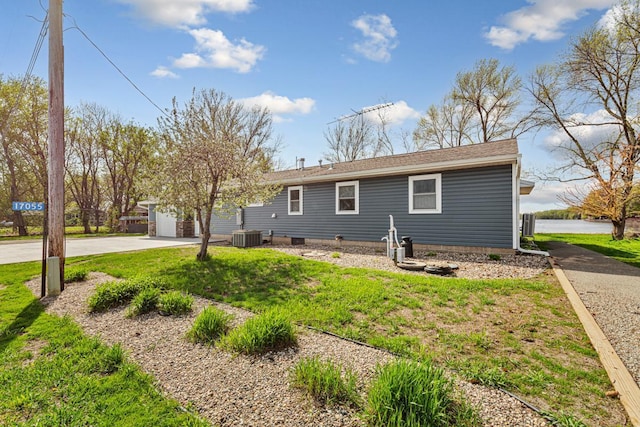 17055 Dickenson Ln, Waterville, MN 56096 - view of front facade featuring concrete driveway, a front lawn, an attached garage, and central AC