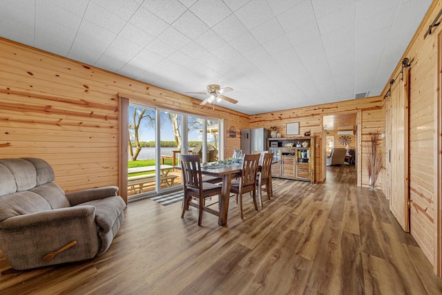 17055 Dickenson Ln, Waterville, MN 56096 - dining area with wood walls, wood finished floors, ceiling fan, and a water view