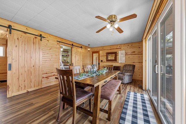 17055 Dickenson Ln, Waterville, MN 56096 - dining area with a barn door, wood finished floors, plenty of natural light, wood walls, and ceiling fan