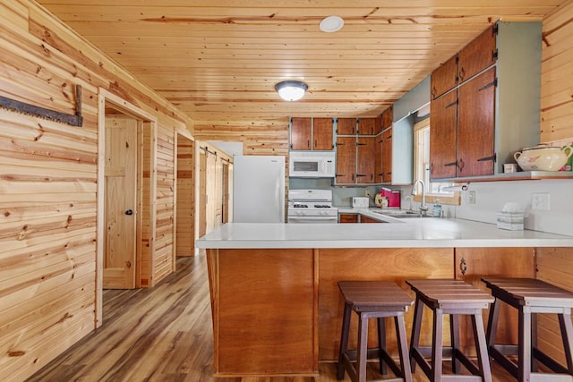 17055 Dickenson Ln, Waterville, MN 56096 - kitchen featuring white appliances, a sink, brown cabinetry, wood ceiling, and a peninsula