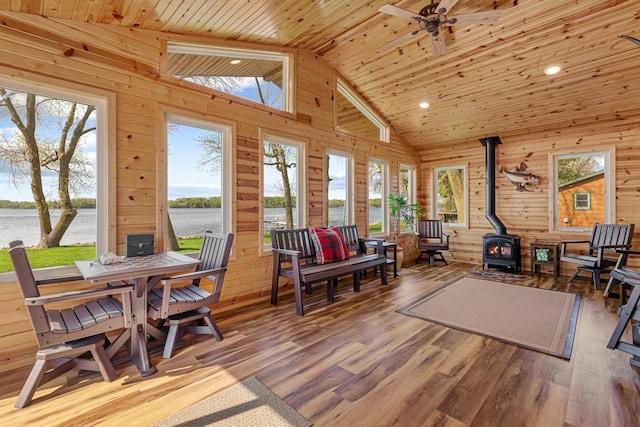 17055 Dickenson Ln, Waterville, MN 56096 - sunroom featuring a wood stove, a water view, vaulted ceiling, and plenty of natural light