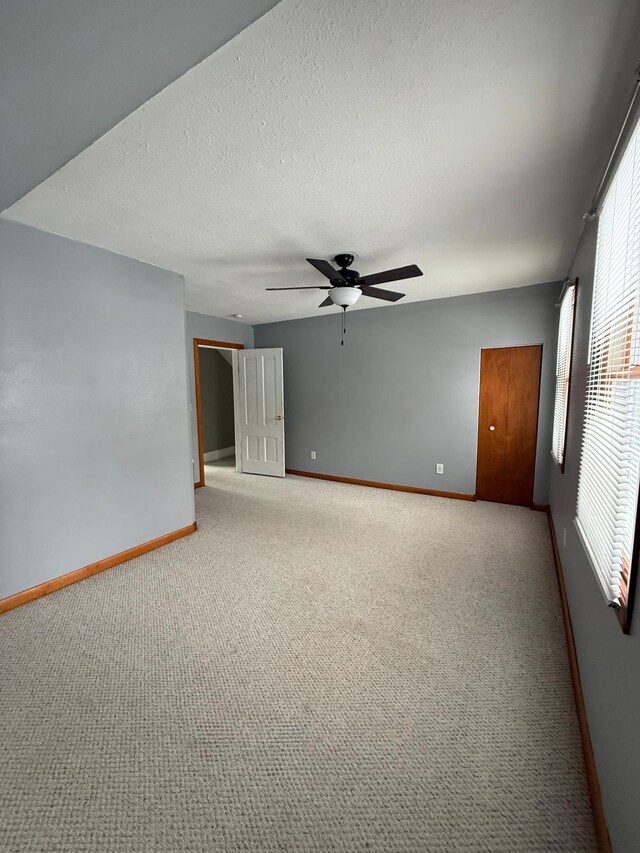 403 7th St N, Kerkhoven, MN 56252 - carpeted empty room featuring baseboards, ceiling fan, and a textured ceiling
