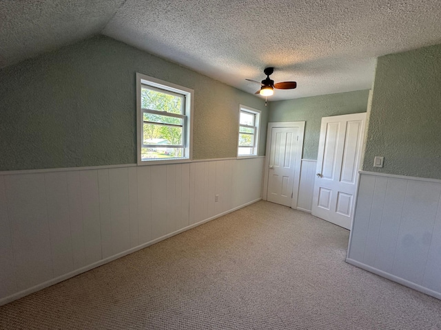 403 7th St N, Kerkhoven, MN 56252 - unfurnished bedroom with a textured ceiling, a textured wall, a wainscoted wall, ceiling fan, and carpet
