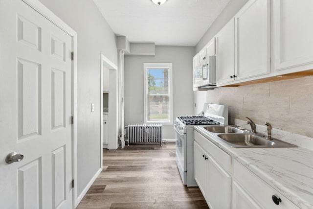 852 Edmund Ave, Saint Paul, MN 55104 - kitchen with radiator, white appliances, a sink, tasteful backsplash, and white cabinetry