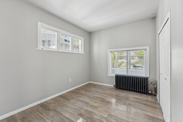 852 Edmund Ave, Saint Paul, MN 55104 - spare room with radiator heating unit, plenty of natural light, wood finished floors, and baseboards