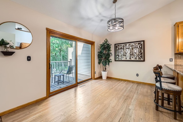 58 Garden Dr, Burnsville, MN 55337 - dining space featuring light wood-type flooring, baseboards, a chandelier, and vaulted ceiling