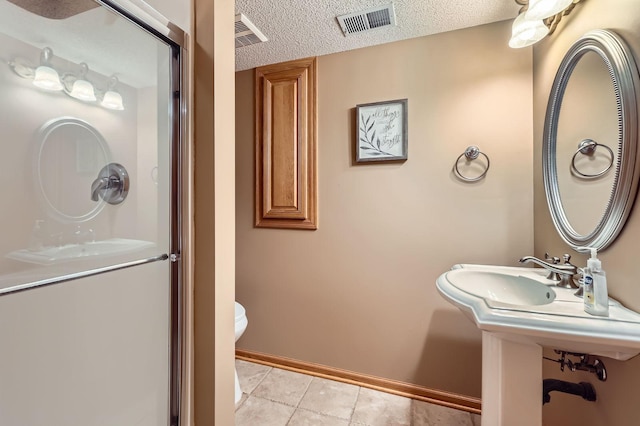 58 Garden Dr, Burnsville, MN 55337 - full bath featuring baseboards, tile patterned floors, a shower stall, toilet, and a textured ceiling