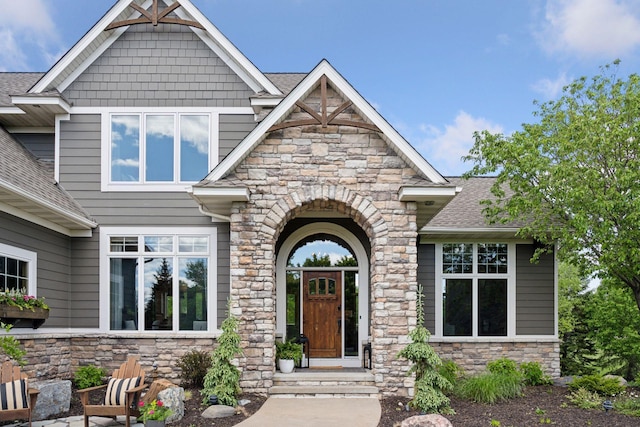 19820 Schutte Farm Rd, Corcoran, MN 55340 - view of exterior entry with stone siding and a shingled roof