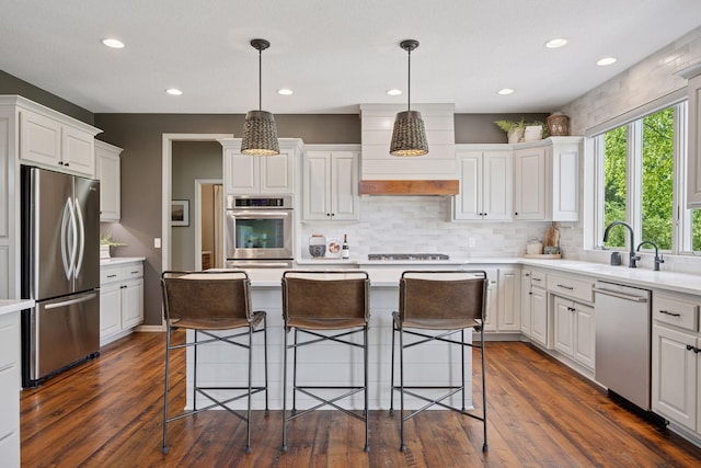 19820 Schutte Farm Rd, Corcoran, MN 55340 - kitchen featuring appliances with stainless steel finishes, white cabinetry, a center island, light countertops, and decorative backsplash