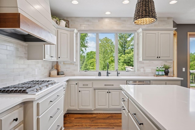 19820 Schutte Farm Rd, Corcoran, MN 55340 - kitchen with a sink, custom exhaust hood, light countertops, stainless steel gas cooktop, and white cabinetry