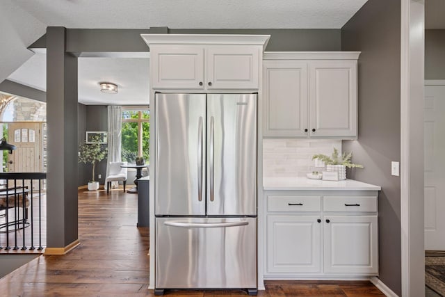 19820 Schutte Farm Rd, Corcoran, MN 55340 - kitchen featuring stainless steel refrigerator, dark wood-type flooring, white cabinets, tasteful backsplash, and a textured ceiling