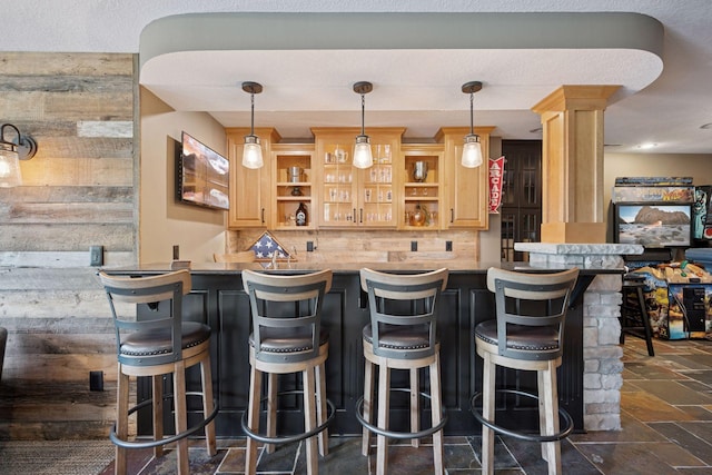 19820 Schutte Farm Rd, Corcoran, MN 55340 - indoor wet bar featuring backsplash, stone tile flooring, hanging light fixtures, and ornate columns