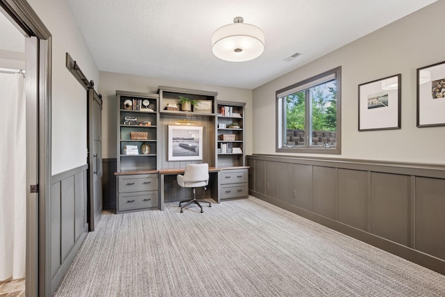 19820 Schutte Farm Rd, Corcoran, MN 55340 - carpeted home office with a barn door, a wainscoted wall, and a decorative wall