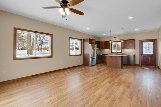 411 Bullis St, Kenyon, MN 55946 - kitchen with stainless steel appliances, healthy amount of natural light, a kitchen island, light wood-style flooring, and recessed lighting