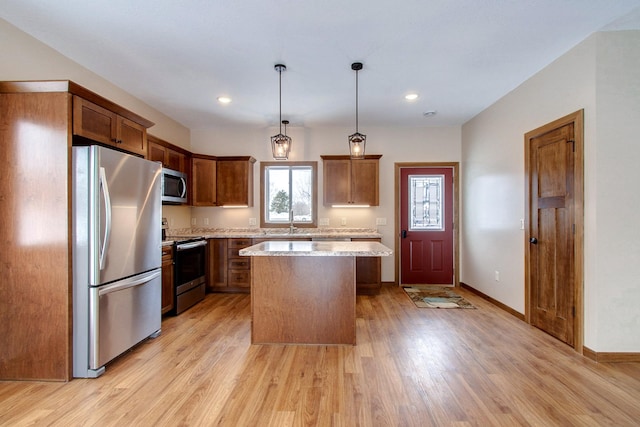 411 Bullis St, Kenyon, MN 55946 - kitchen featuring stainless steel appliances, light wood-style floors, a kitchen island, light stone counters, and recessed lighting