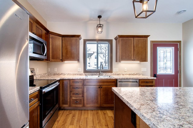 411 Bullis St, Kenyon, MN 55946 - kitchen featuring stainless steel appliances, light wood finished floors, light countertops, and brown cabinetry