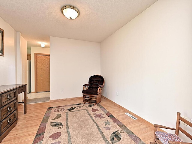 38850 Christie Ln, Cohasset, MN 55721 - sitting room featuring light wood-style flooring, a textured ceiling, and baseboards