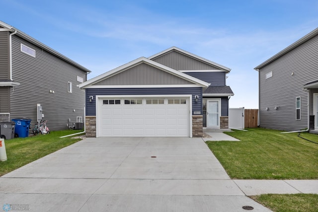 craftsman house featuring stone siding, a front lawn, board and batten siding, and concrete driveway