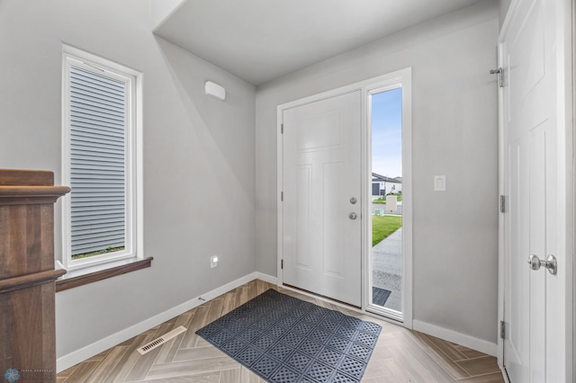 foyer featuring plenty of natural light and baseboards