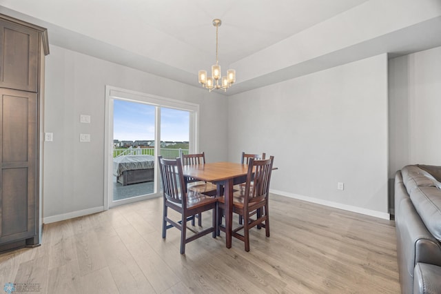 dining area featuring baseboards, a chandelier, and light wood finished floors