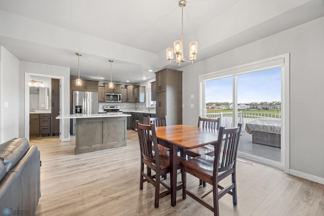 dining area featuring a chandelier, light wood finished floors, baseboards, and recessed lighting