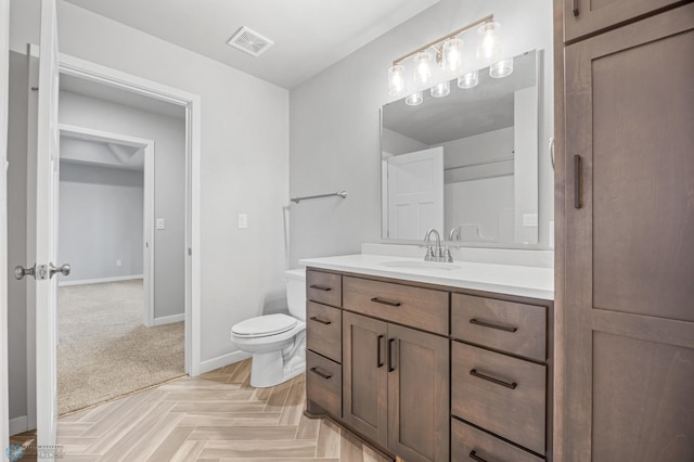 bathroom with toilet, baseboards, and vanity