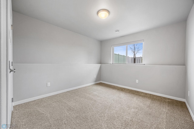 carpeted empty room featuring baseboards