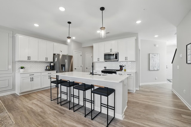 192 Junco Rd N, Lake Elmo, MN 55042 - kitchen featuring appliances with stainless steel finishes, a sink, tasteful backsplash, a kitchen breakfast bar, and recessed lighting
