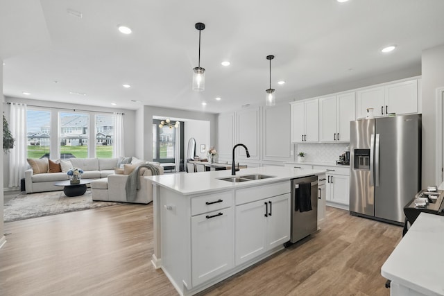192 Junco Rd N, Lake Elmo, MN 55042 - kitchen featuring appliances with stainless steel finishes, a sink, light countertops, light wood finished floors, and decorative light fixtures