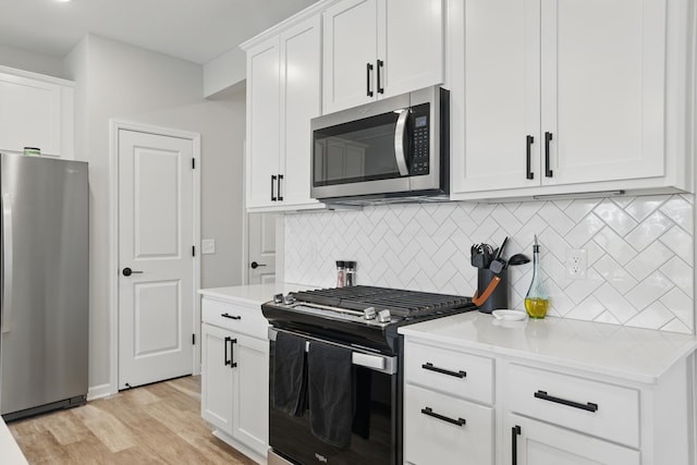 192 Junco Rd N, Lake Elmo, MN 55042 - kitchen with stainless steel appliances, tasteful backsplash, light countertops, and white cabinetry