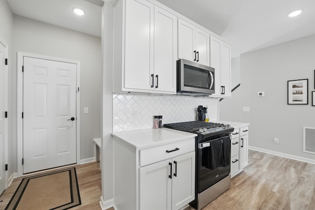 192 Junco Rd N, Lake Elmo, MN 55042 - kitchen featuring appliances with stainless steel finishes, light wood-type flooring, light countertops, backsplash, and baseboards