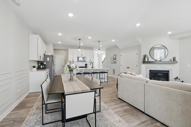 192 Junco Rd N, Lake Elmo, MN 55042 - dining area with recessed lighting, light wood-type flooring, a premium fireplace, and baseboards