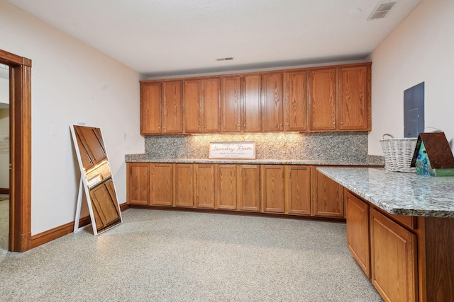 5225 Upland Ave, New Germany, MN 55367 - kitchen with brown cabinetry, decorative backsplash, stone countertops, and a peninsula