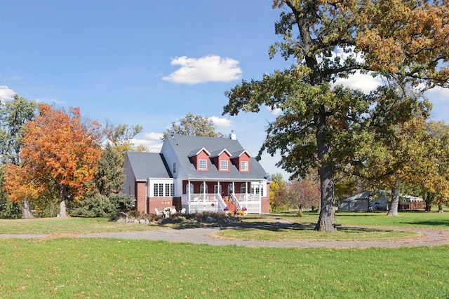 5225 Upland Ave, New Germany, MN 55367 - cape cod house featuring covered porch, a front lawn, a chimney, and brick siding