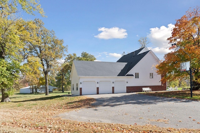 5225 Upland Ave, New Germany, MN 55367 - view of property exterior featuring asphalt driveway, an attached garage, and roof with shingles