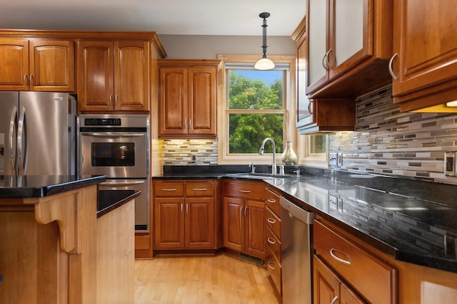 1376 Cobblestone Rd N, Champlin, MN 55316 - kitchen featuring stainless steel appliances, brown cabinets, light wood finished floors, and backsplash