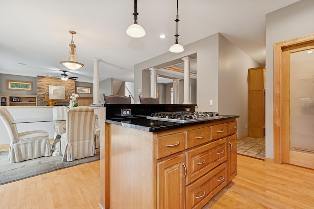 1376 Cobblestone Rd N, Champlin, MN 55316 - kitchen with decorative columns, stainless steel gas cooktop, a ceiling fan, and light wood-style flooring