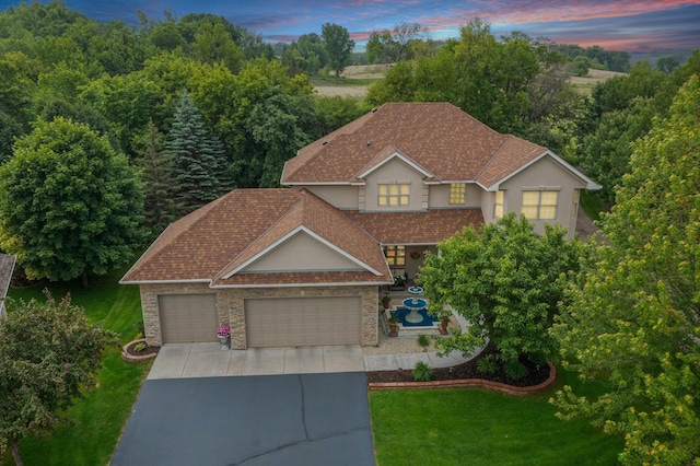 1376 Cobblestone Rd N, Champlin, MN 55316 - traditional-style home featuring concrete driveway, a lawn, an attached garage, stucco siding, and stone siding